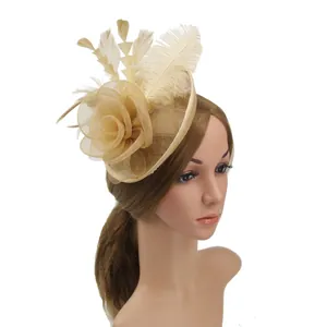 Detail of vintage champagne mesh fascinator hat with elegant feathers and floral lace
