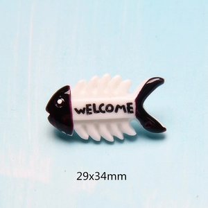 Macro detail of a 29x34mm white resin fishbone accessory with Welcome text and purple accents