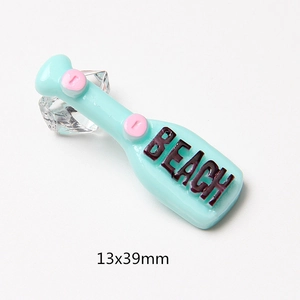 Close-up of beach bottle resin charms in light blue with pink dots and 13x39mm size