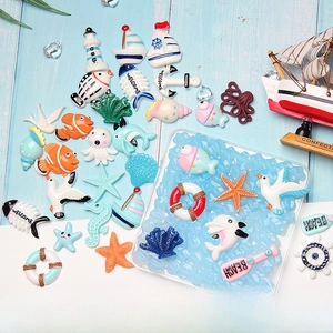 Flat lay of ocean themed resin charms like starfish and anchors for DIY phone case crafts