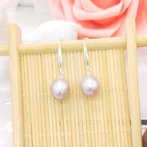 Detail of pink freshwater pearl earrings with S925 silver hooks on a bamboo display stand