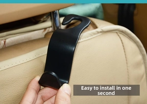 Close-up of black car headrest hook being installed on a seat for easy organization