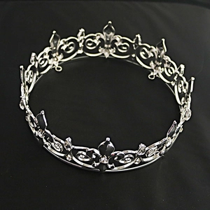 Close-up of silver bridal crown with Fleur-de-lis design and clear rhinestones