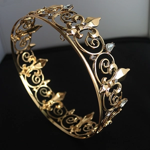 Close-up of golden vintage crown with sparkling white crystals and floral patterns