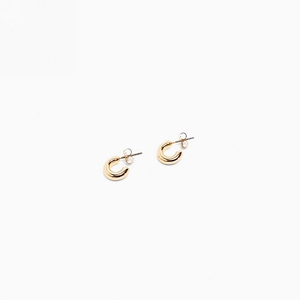 Detail of minimalist golden C-shaped hoop earrings with polished metal finish and backs