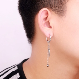Silver punk style tassel earrings with long chains and conical charms on a male model