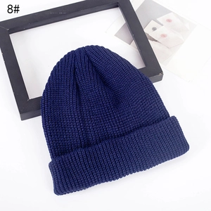 Classic navy blue ribbed knit beanie hat with cuff fold on a white decorative background