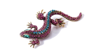 Detailed macro view of retro gecko brooch with pink blue crystals and green rhinestone eyes