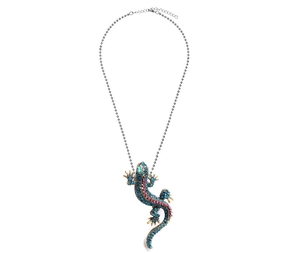 Close-up of gecko pendant with blue-pink crystals on golden base and silver chain