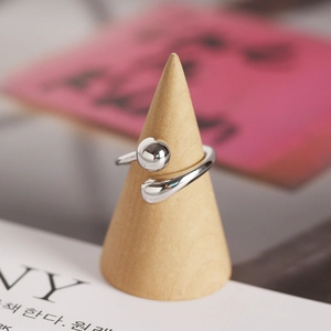 Detail of silver S925 minimalist bead ring on a wooden cone stand with polished finish