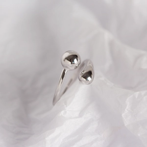 Close-up of minimalist S925 silver open ring with smooth silver ball and teardrop ends
