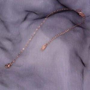 18K rose gold plated stainless steel lip link chain necklace on textured purple fabric