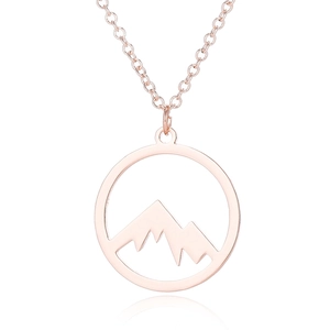 Close-up of rose gold hollow circular pendant featuring a stylized mountain range design