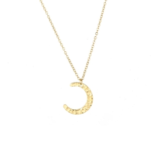 Close-up of golden moon pendant necklace with detailed hammered texture on a white background