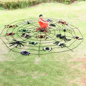 Huge round Halloween spider web with colorful plush spiders displayed on outdoor green lawn