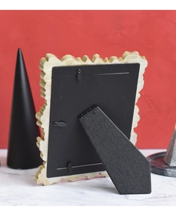 Detail view of the ornate beige picture frame back with sturdy stand and metal clips