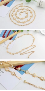 Detail of elegant gold metal waist chain featuring white faux pearls for dresses