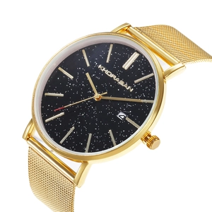 Detail of the golden Milanese strap and black starry dial with a practical date display