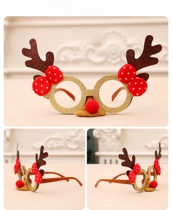 Detail of Christmas reindeer antler glasses with gold glitter frames and red polka dot bow