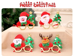 Close-up of four Christmas glasses with reindeer antlers and Santa designs in gold glitter