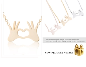 Detailed view of heart gesture pendant necklaces in gold, silver and rose gold finishes