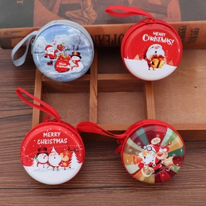 Detail of Christmas tinplate coin purses with Santa and reindeer motifs in a wooden tray