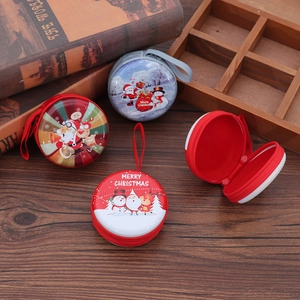 Detail of round metal Christmas coin purses with festive Santa and snowman illustrations