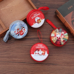 Close-up of assorted round Christmas tin coin purses with Santa and snowman patterns
