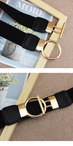 Détail d'une ceinture élastique noire avec boucle en T dorée et anneau métallique