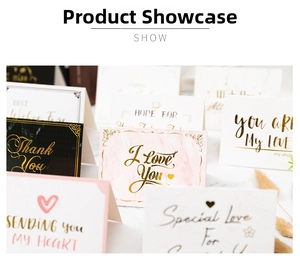 Close-up of assorted gift cards with gold foil lettering on marble background