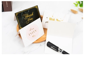 Close-up of elegant gold foil Thank You cards with marble patterns and stationery