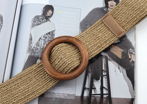 Detail of bohemian woven belt featuring a round wooden buckle and natural fiber texture