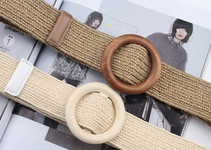 Detail view of woven belts with round wooden buckles in khaki and beige tones