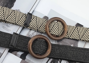 Detail of woven elastic belts with round wooden buckles and black leather accents