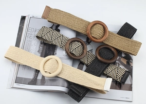 Detail of four woven elastic belts with large round wooden buckles in bohemian style