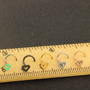 Five-piece heart nose ring set in mixed metallic finishes shown with measuring ruler