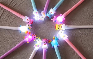 Dettaglio di quattro penne con animali luminosi disposte in un cerchio creativo