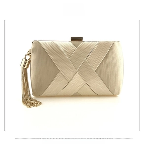 Detailed front view of champagne gold satin clutch with woven texture and fringe