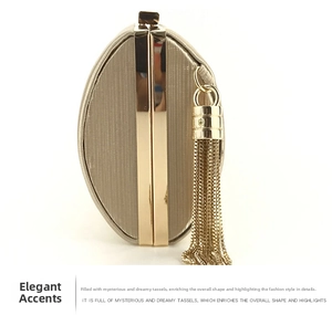Detail of champagne gold evening clutch featuring elegant metal tassel and vertical texture
