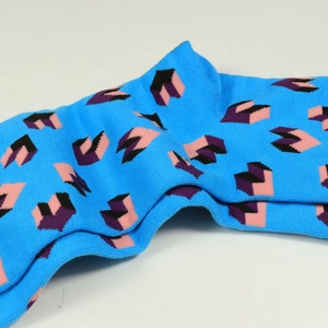 Détail de chaussettes en tricot aux motifs de puzzle bleu, rose et violet vif