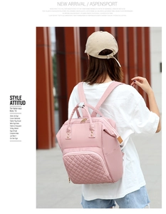 Pink quilted nylon backpack for moms featuring embroidered details in an outdoor setting