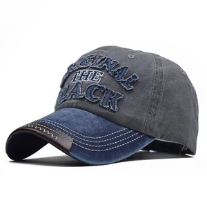Detail of vintage washed cotton baseball cap with embroidered letters and denim patchwork