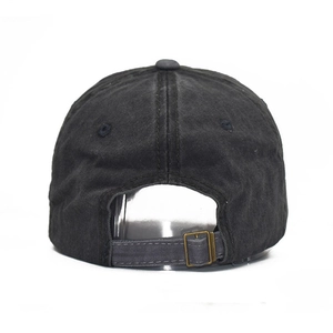 Detail of adjustable bronze metal buckle and washed denim texture on baseball cap
