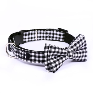 Detail of pet collar with black and white plaid bowknot, plastic buckle and metal D-ring