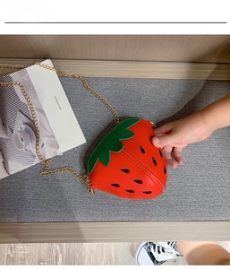 Detail einer süßen Erdbeer-Umhängetasche aus PU-Leder für Kinder mit goldener Kette