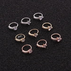 Macro detail of 8mm nose rings in gold, silver, and rose gold with zircon stone inlays