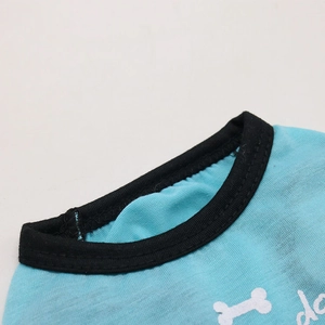 Détail du gilet bleu clair pour animaux avec bordure noire et motif d'os imprimé