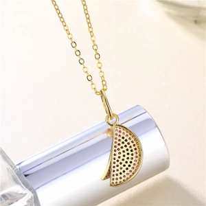 Golden watermelon pendant necklace with pink and black zircon crystals on long chain
