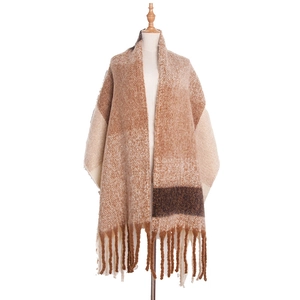 Close-up of brown and beige checkered scarf with soft knit texture and long fringe details