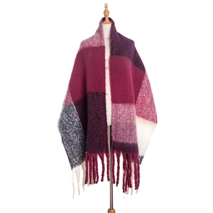 Detail shot of oversized thick plaid scarf featuring soft red and blue fringe textures